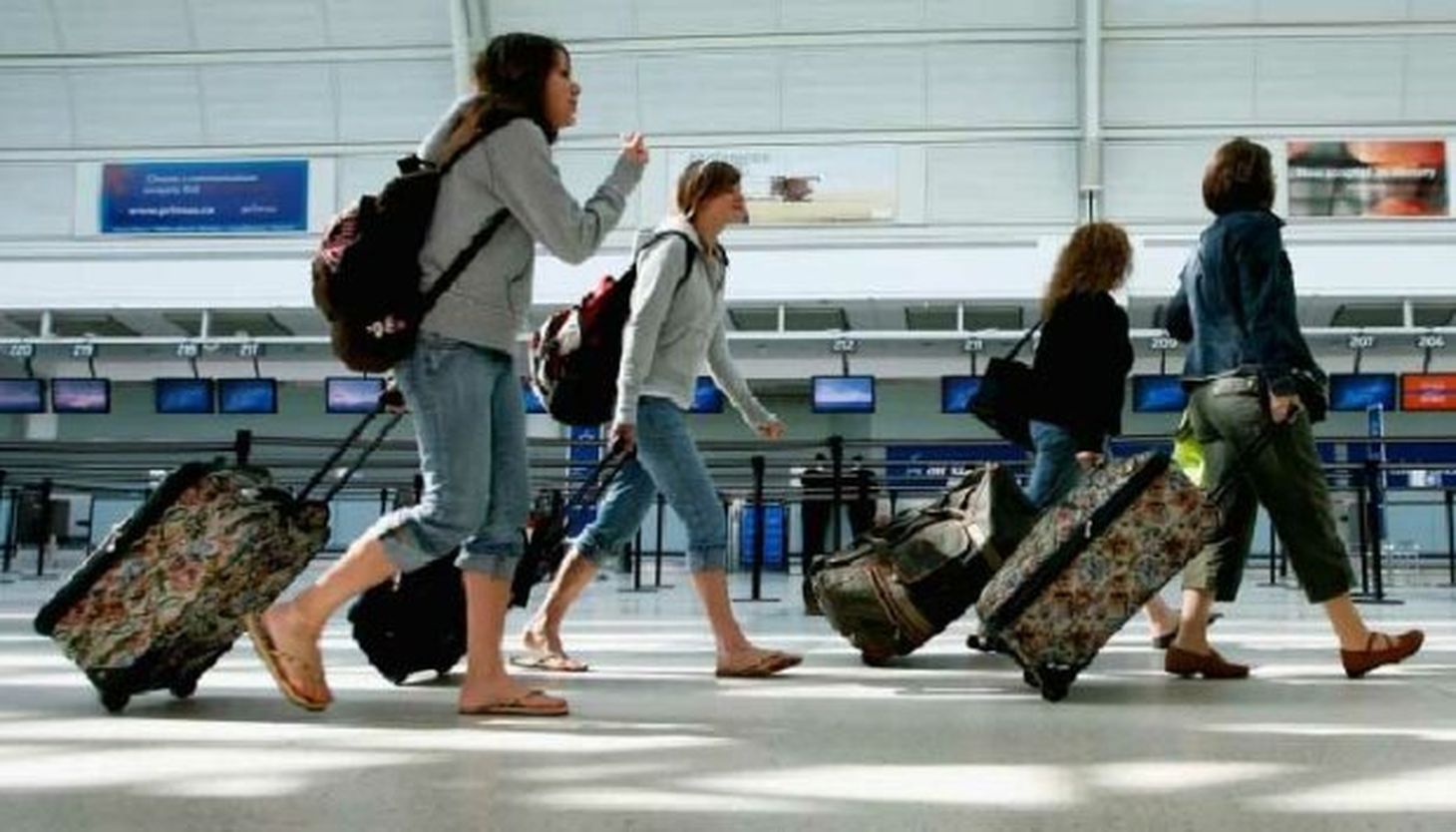 Приезжающие из заграницы. Туристы в аэропорту. Люди с чемоданами в аэропорту. Путешественник в аэропорту. Отдыхающие в аэропорту.