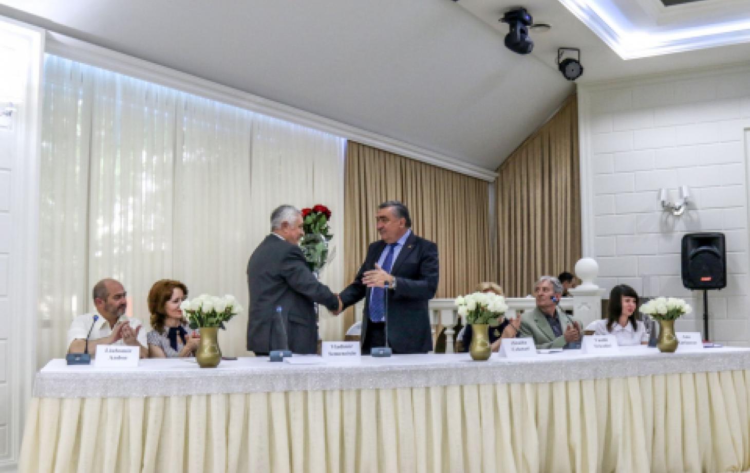 Владимир Семенчишин принимает букет и поздравления от депутата Парламента Владимира Хотиняну.